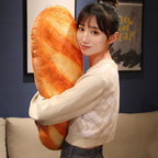 Woman holding a large baguette-shaped plush pillow, showing the life-size scale and cozy hugging use.
