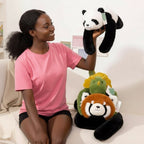 Woman holding a panda plushie on a couch with dino and red panda plushies.
