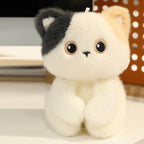 Little Cuddle Buddies mini cream kitten with gray and brown ears plush toy on desk