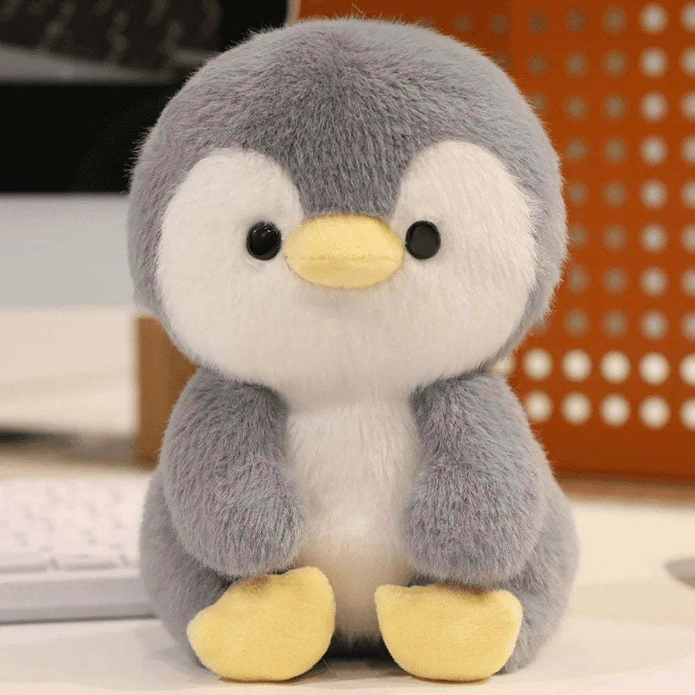 Little Cuddle Buddies mini white and gray penguin with yellow feet and beak plush toy on desk