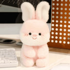 Little Cuddle Buddies mini pink rabbit with long ears plush toy on computer desk