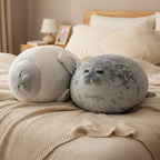 Sleepy Buddies chubby seal plush toys resting on a cozy bed in a soft neutral bedroom