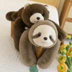 Two plushpes brown bear and  sloths on a bed with flowers in the background