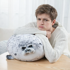 Boy resting on a sleepy-buddies seal plush cushion, stuffed animal pillow for comfort and relaxation