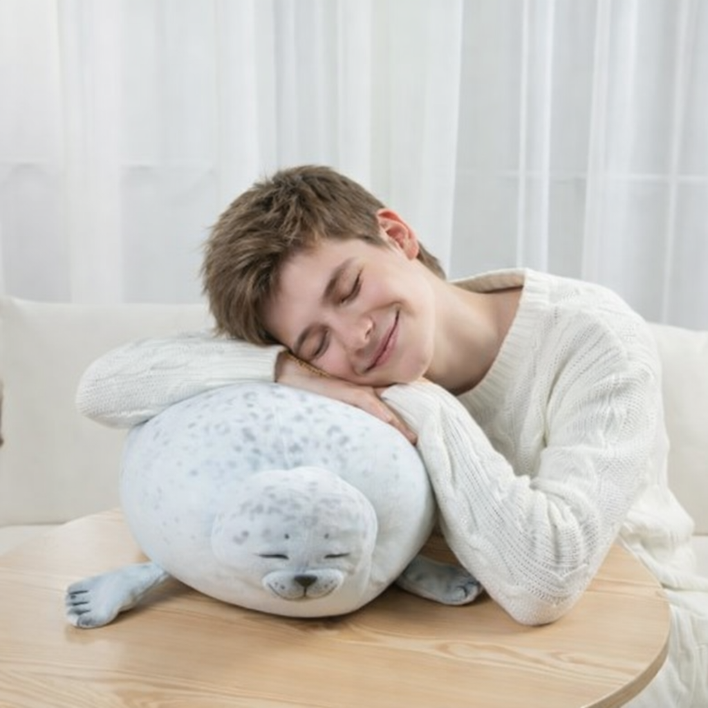 Young man peacefully resting on a sleepy-buddies sleeping seal plush happy pillow, soft stuffed animal cushion for relaxation and comfort